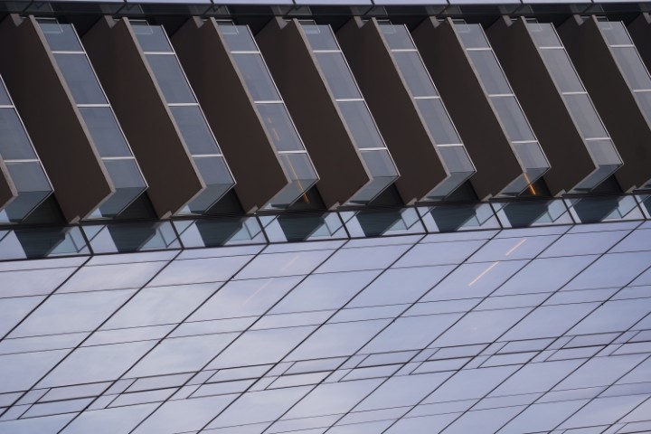 Detailed view of a glass building in Times Square. A series of balconies and windows are visible.
